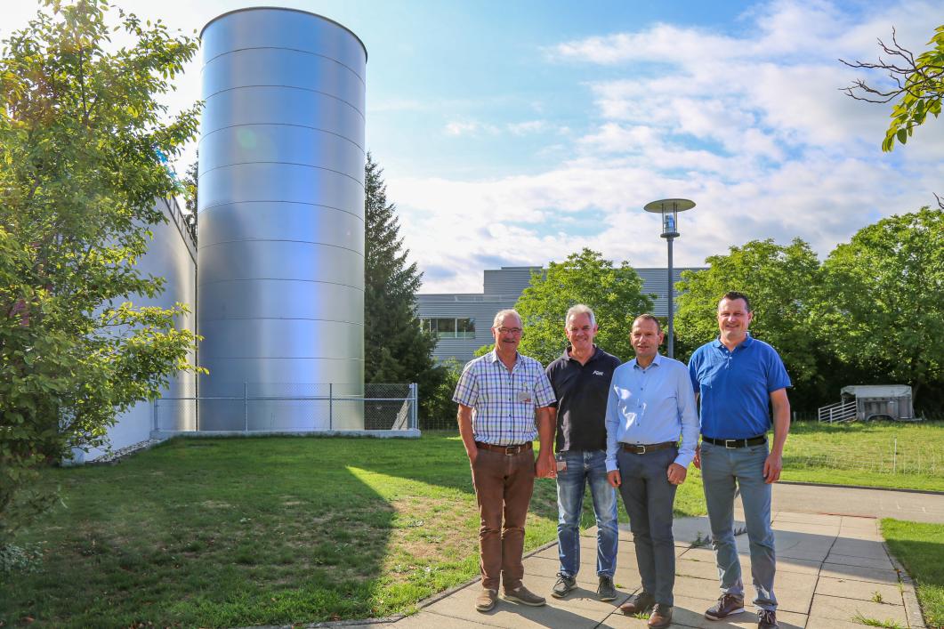 Hier wird das Warmwasser gespeichert. Die Projektverantwortlichen, von links: Urs Lustenberger (Gemeinderat Zell), Marcel Kränzlin (AEW Energie AG), Stephan Wolf und Roland Roos (Bell Schweiz AG). Foto: Astrid Bossert Meier